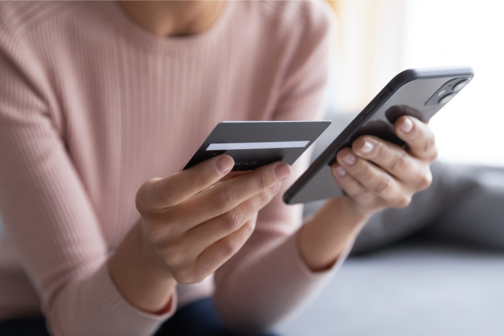 A woman entering bank card details into a phone.