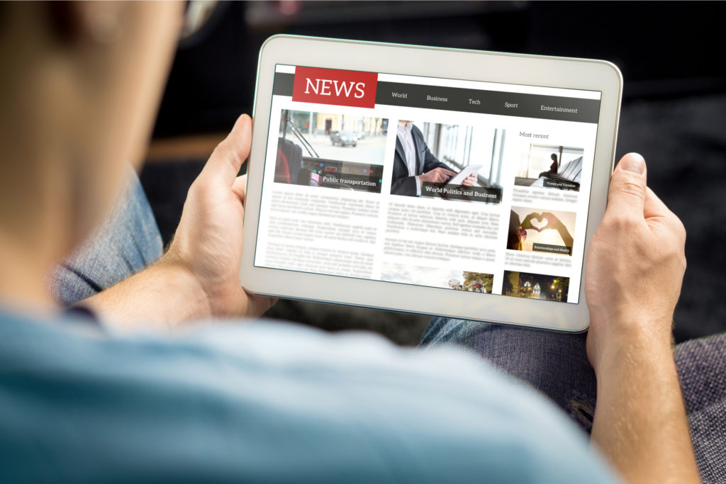 A man reading the news on a tablet.