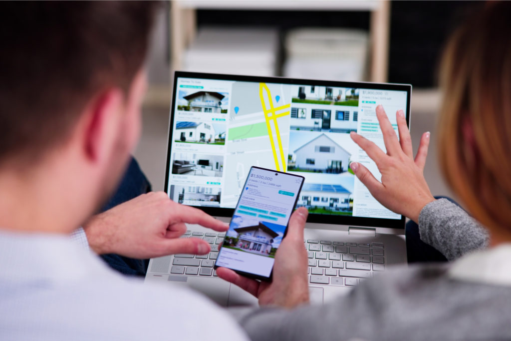 A couple looking at properties sale on a laptop.