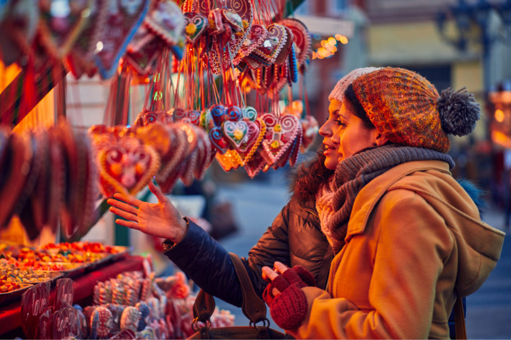 Two women looking at a Christmas market stall.