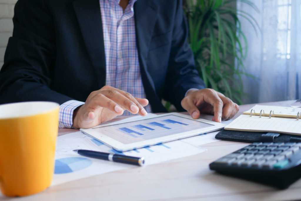 Business man looking at charts on a tablet.