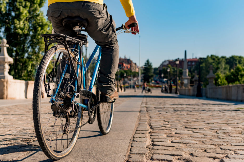 A man riding a bike through a city.