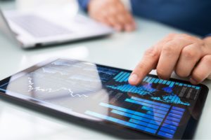 A man looking at graphs on a tablet.