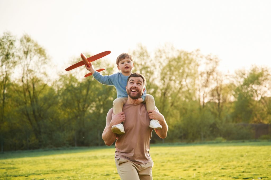 A father with a child sitting on his shoulders.