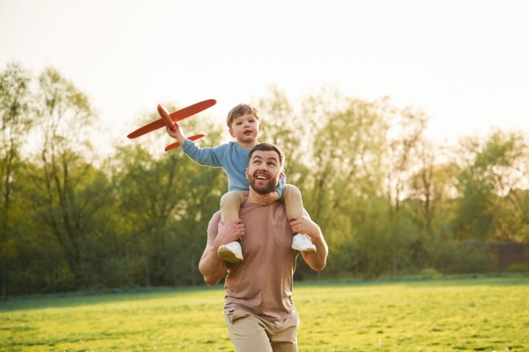 A father with a child sitting on his shoulders.